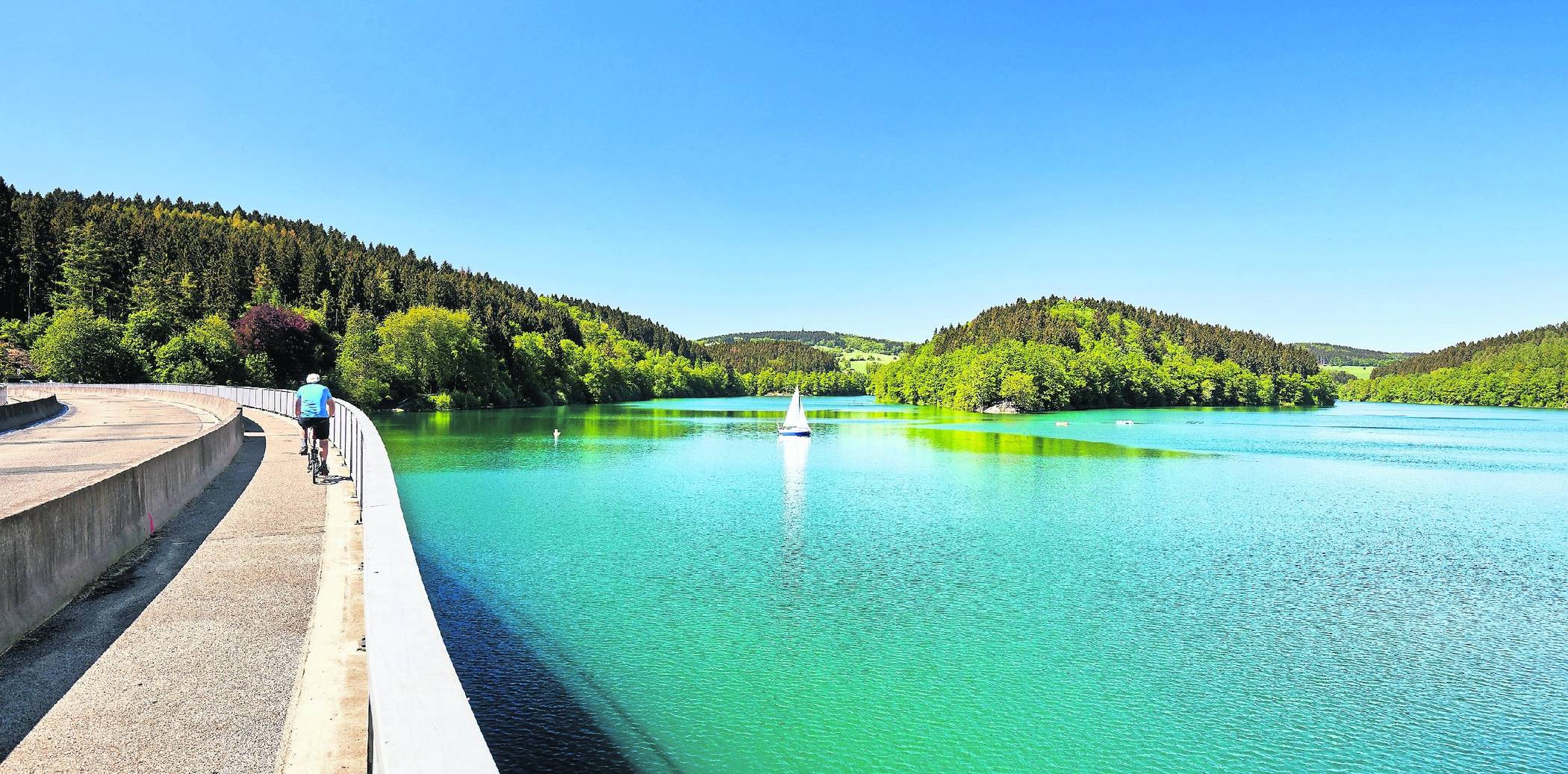  Der Bergische Panorama-Radweg führt über die imposante Aggertalsperre am spiegelglatten Stausee entlang. 